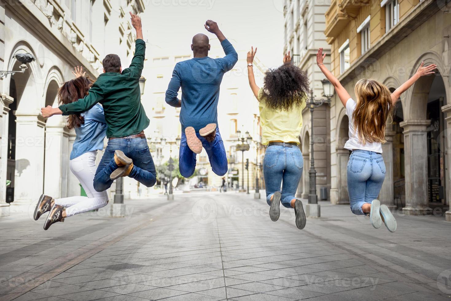 Group of friends jumping together outdoors photo