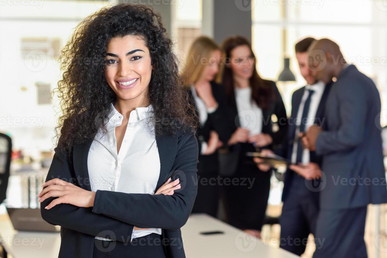 Líder empresaria en la oficina moderna con empresarios que trabajan en segundo plano. foto