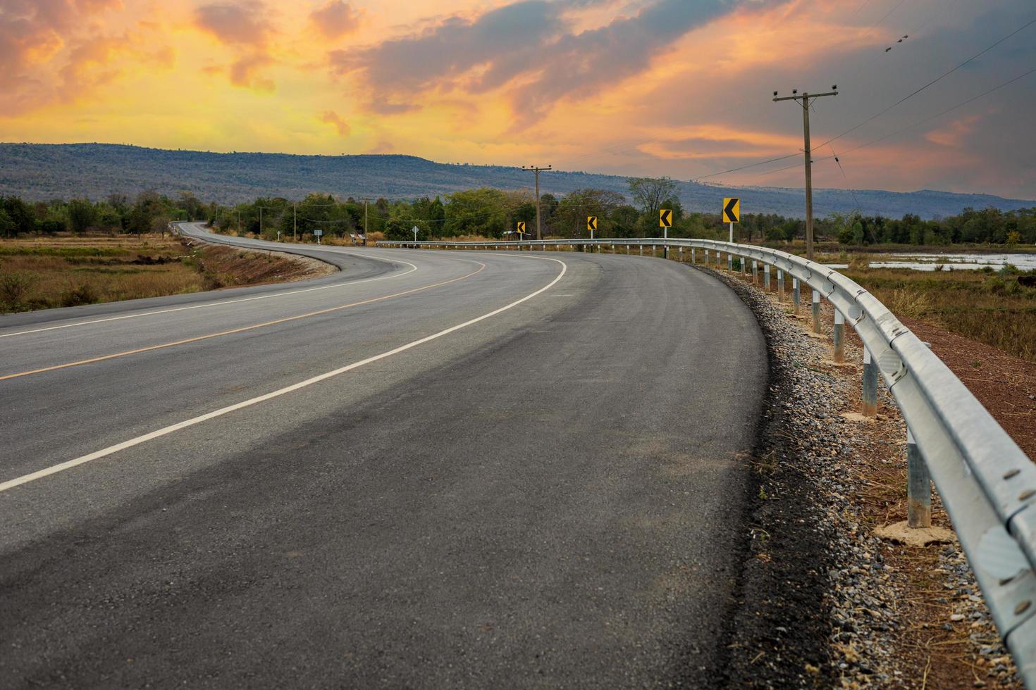 The road leads to the beautiful mountains and sky at sunset photo