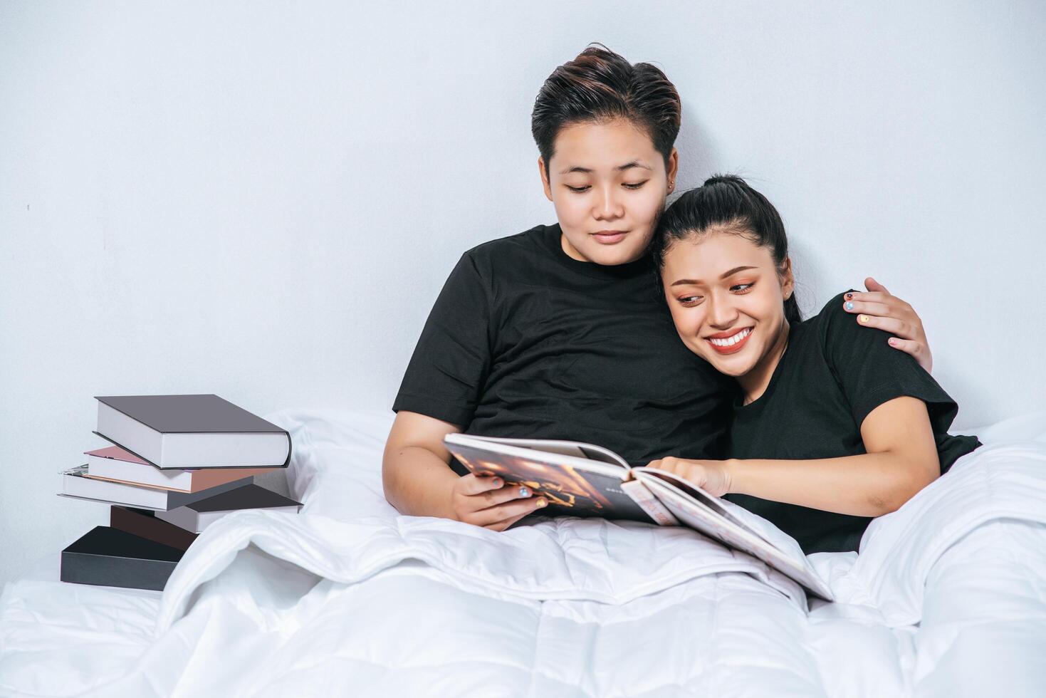 dos parejas de mujeres abrazados juntos en la cama. foto