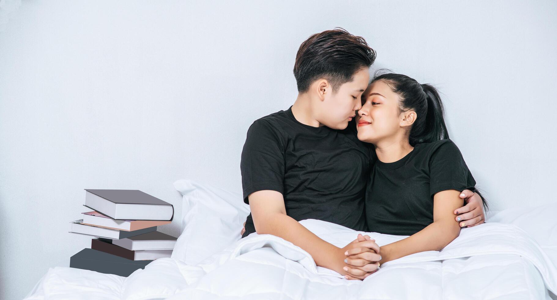 Two female couples cuddled together in bed. photo