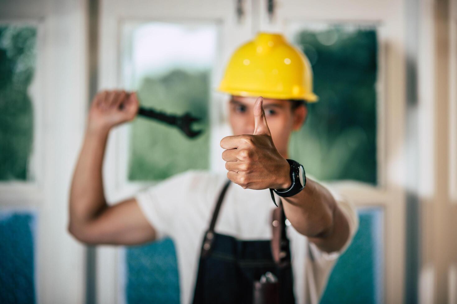 un técnico sostiene un destornillador y sostiene un pulgar. foto