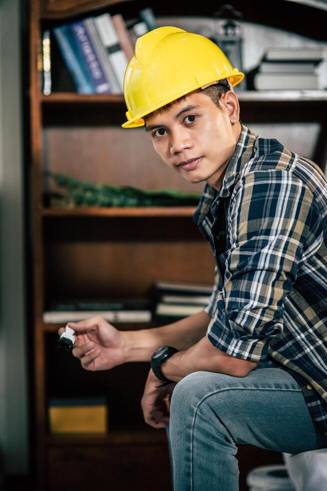 A carpenter holds a paintbrush and paints wood. photo