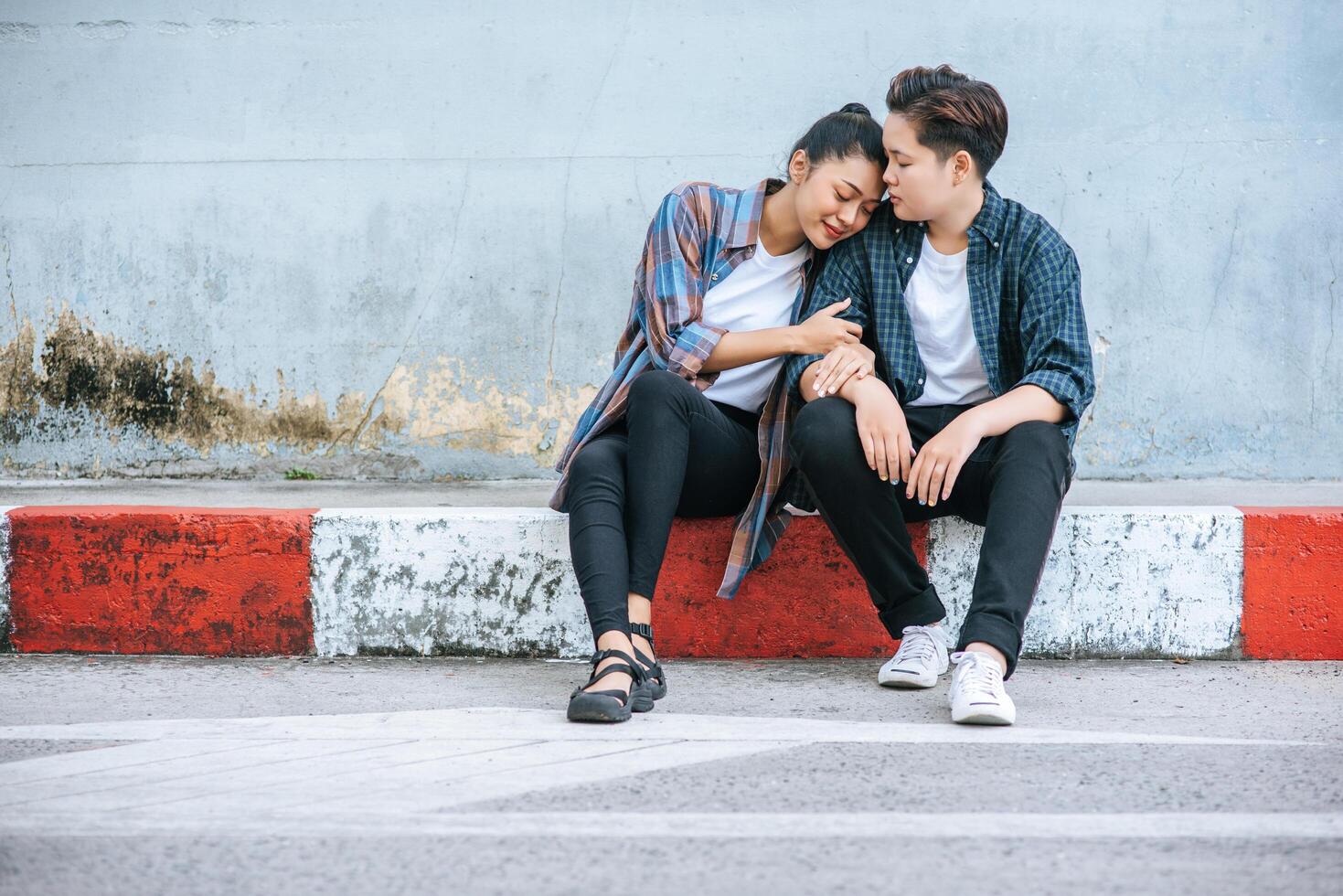 A woman sitting on each other's shoulders by the road. photo