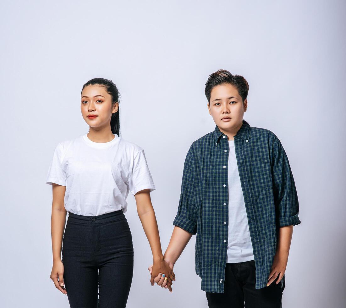 Two loving women standing and holding hands. photo