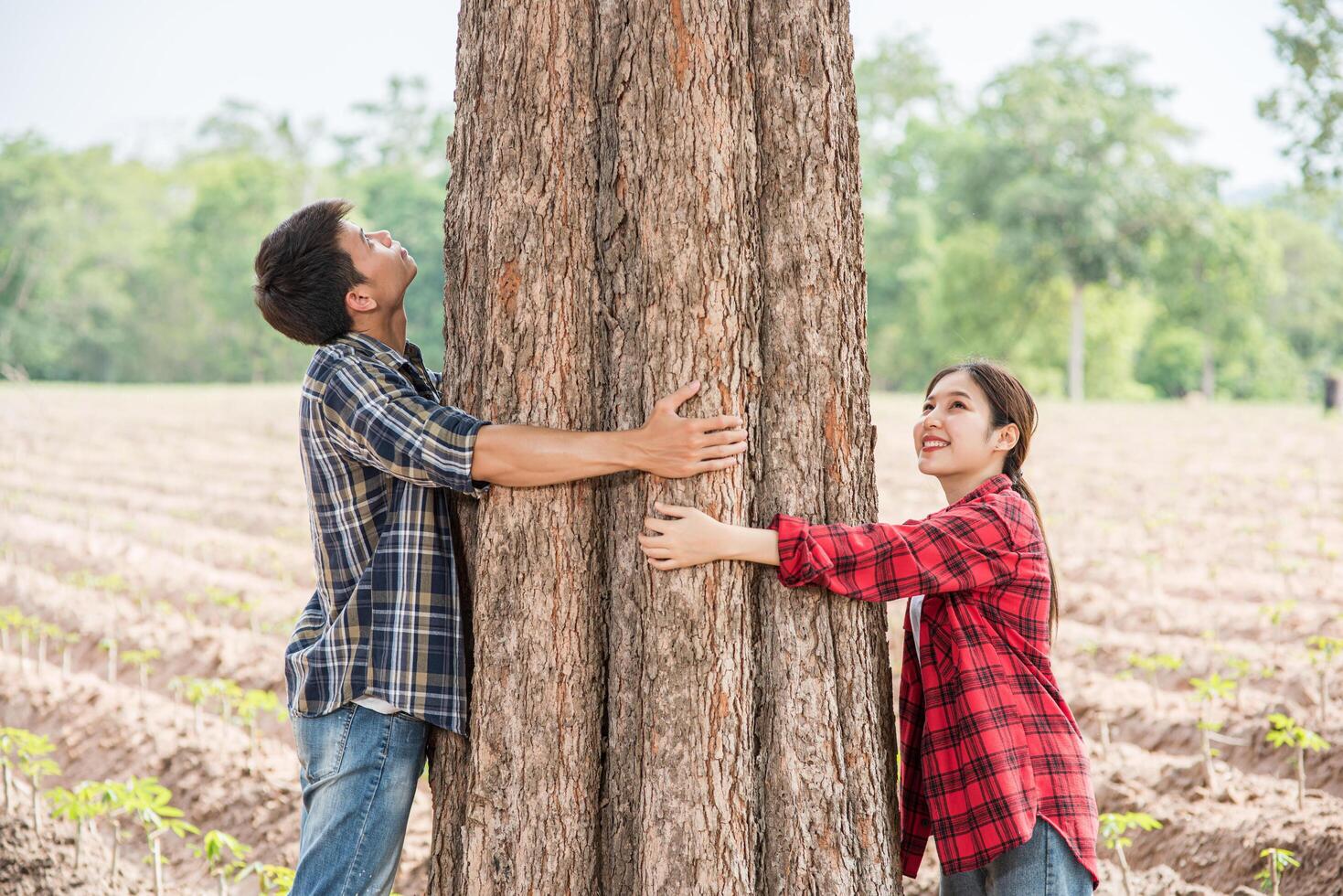 Men and women standing and hugging trees. photo