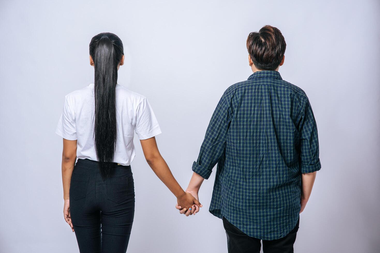 Two loving women standing and holding hands. photo