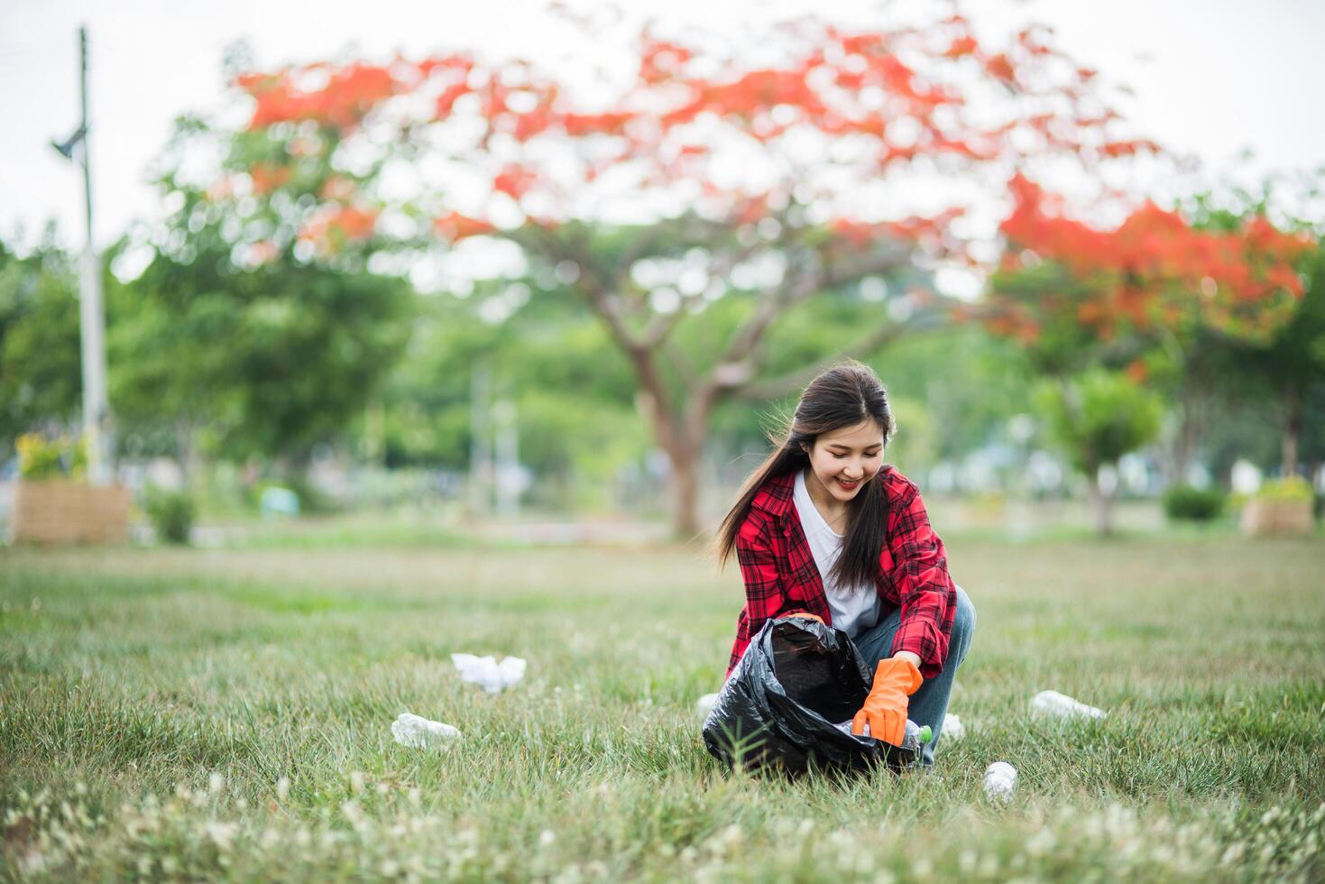 mujer recogiendo basura en una bolsa negra. foto