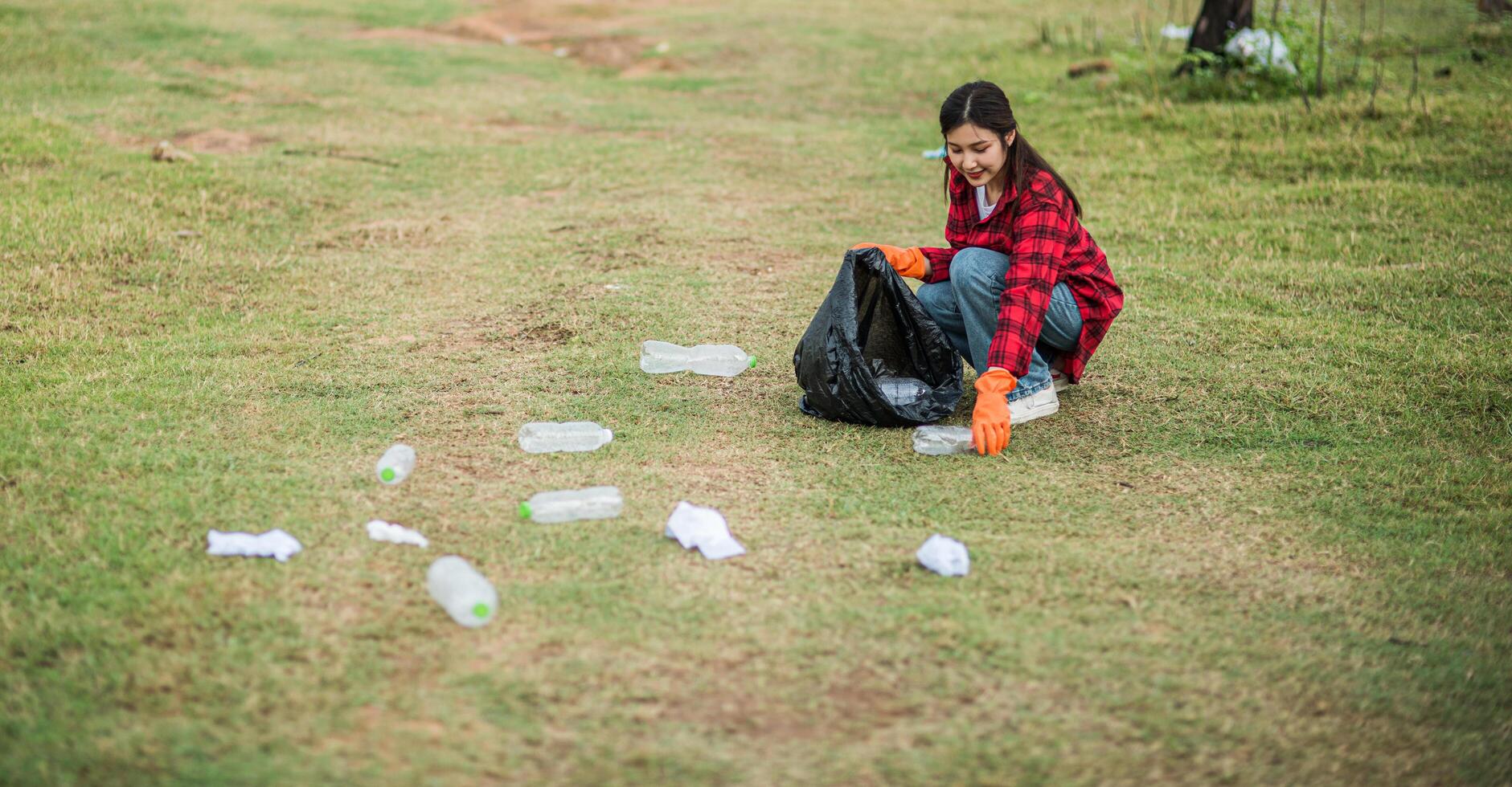 woman collecting garbage in a black bag. photo