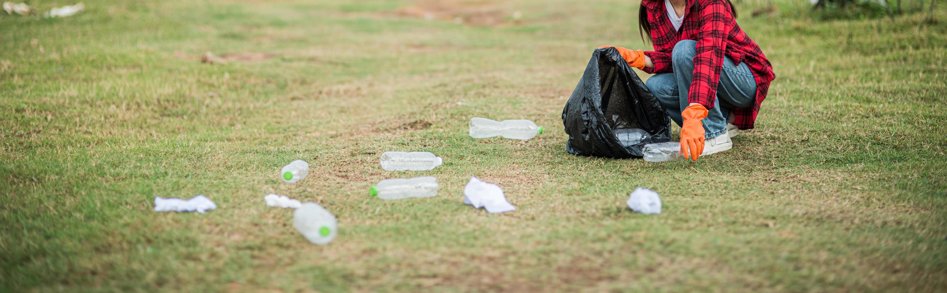 mujer recogiendo basura en una bolsa negra. foto