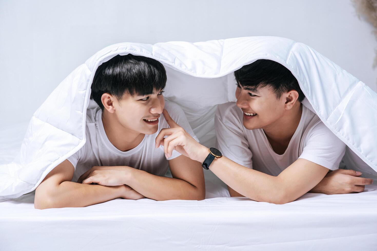 Two beloved young men slept in bed together. photo