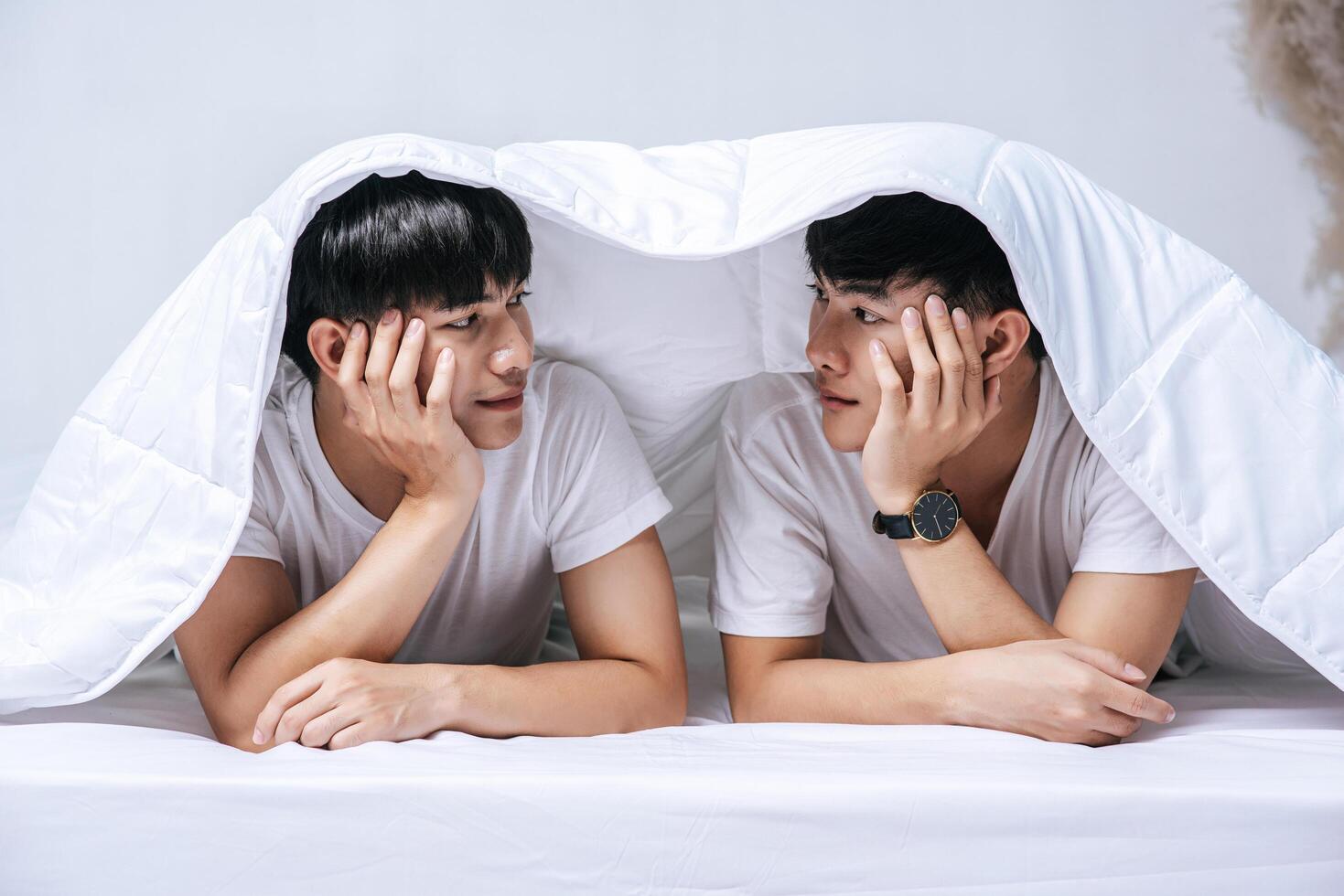 Two beloved young men slept in bed together. photo