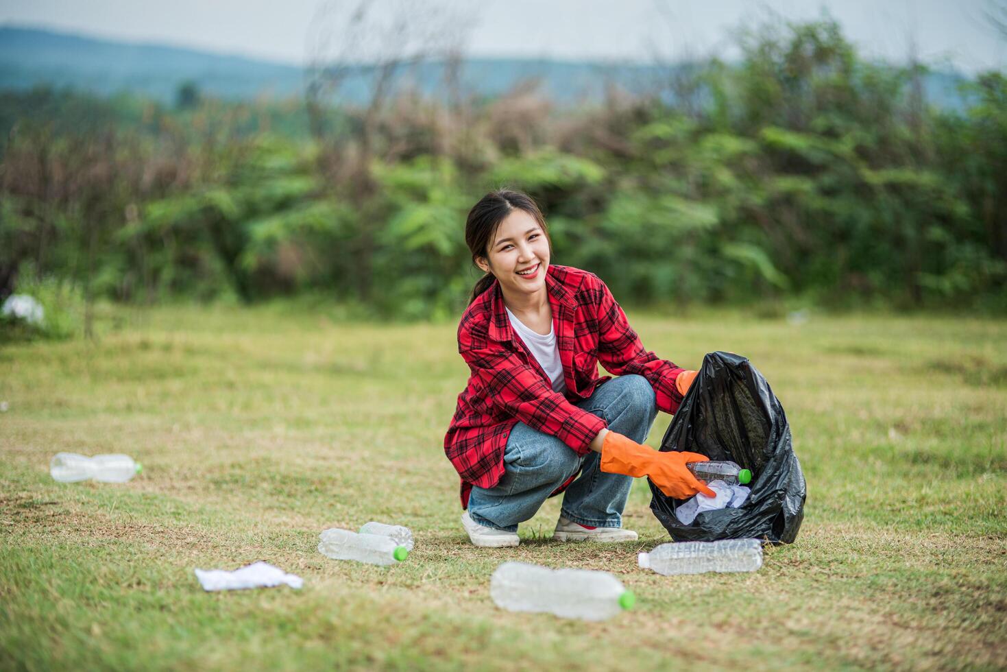 woman collecting garbage in a black bag. photo