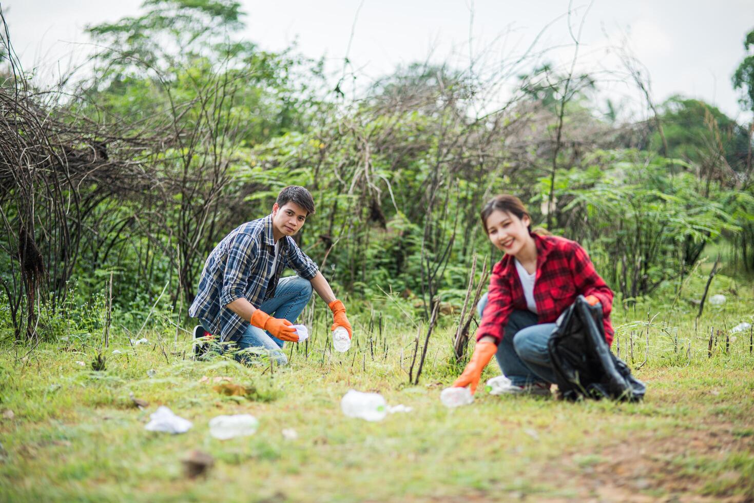 Men and women help each other to collect garbage. photo