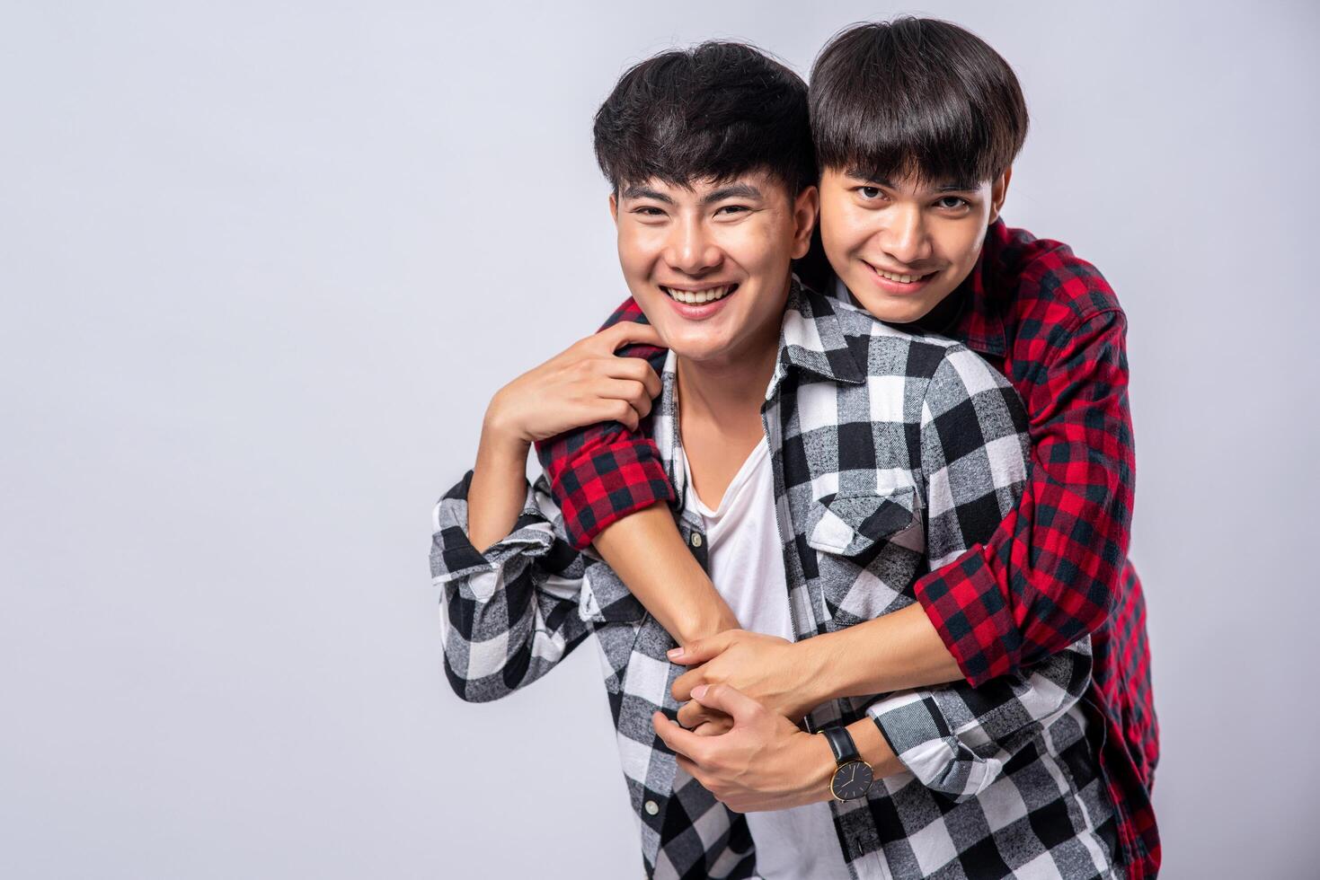 Two men who love each other hug from behind another. photo