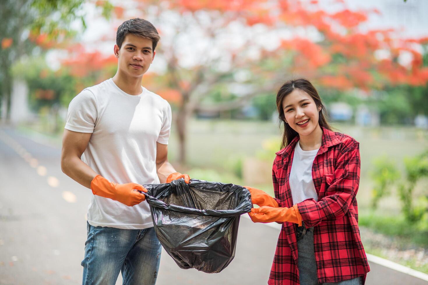 hombres y mujeres se ayudan mutuamente a recoger basura. foto