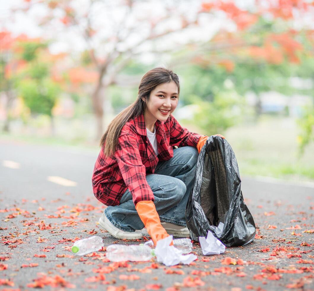 woman collecting garbage in a black bag. photo