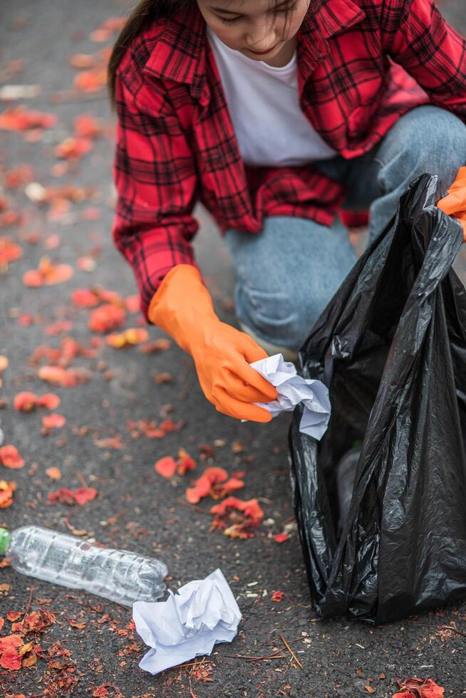 mujer recogiendo basura en una bolsa negra. foto