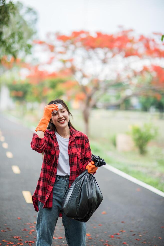 woman collecting garbage in a black bag. photo