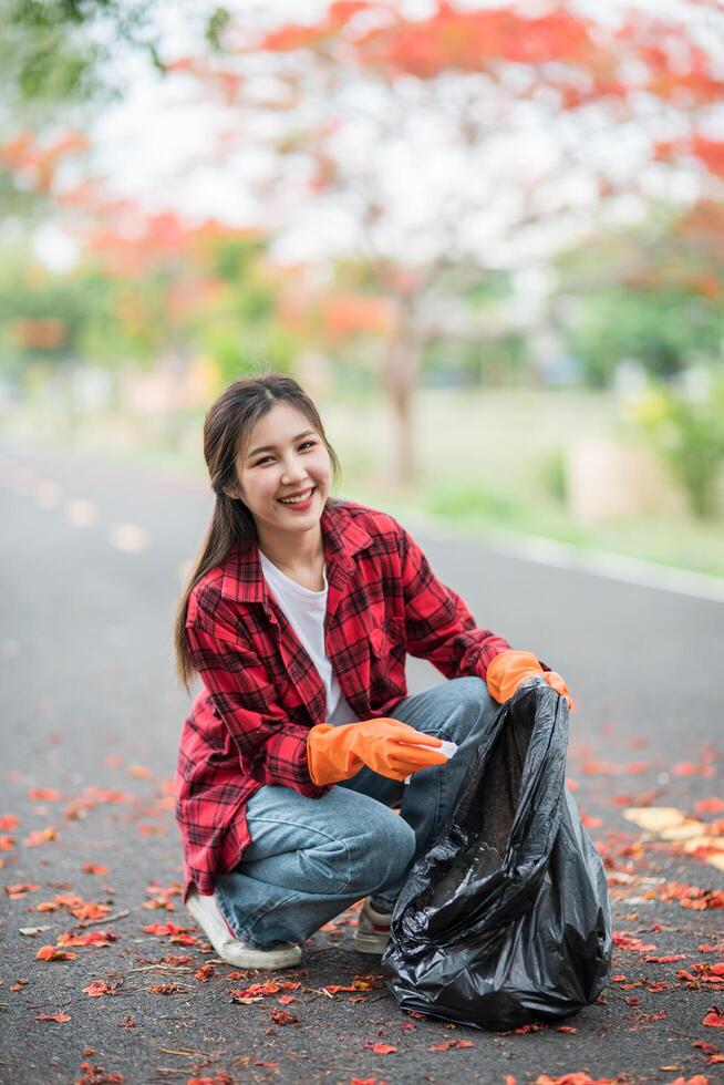 woman collecting garbage in a black bag. photo