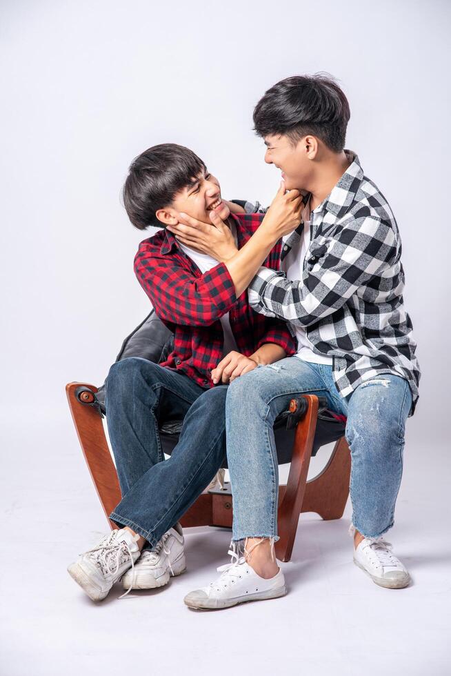 Two men who love each other hug and sit on a chair. photo
