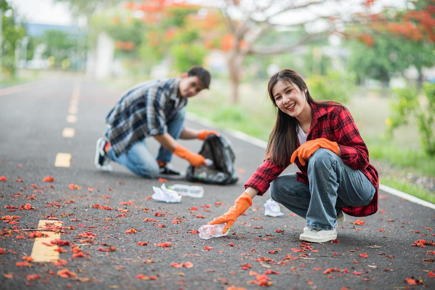 hombres y mujeres se ayudan mutuamente a recoger basura. foto