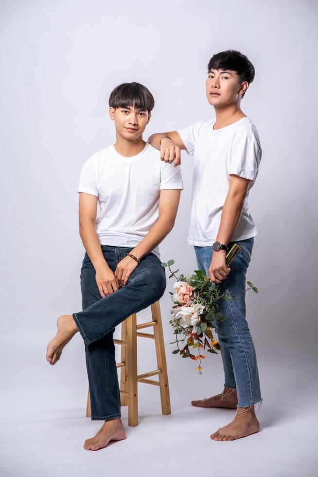 Two lovers, hands resting on their shoulders and sitting on a chair. photo