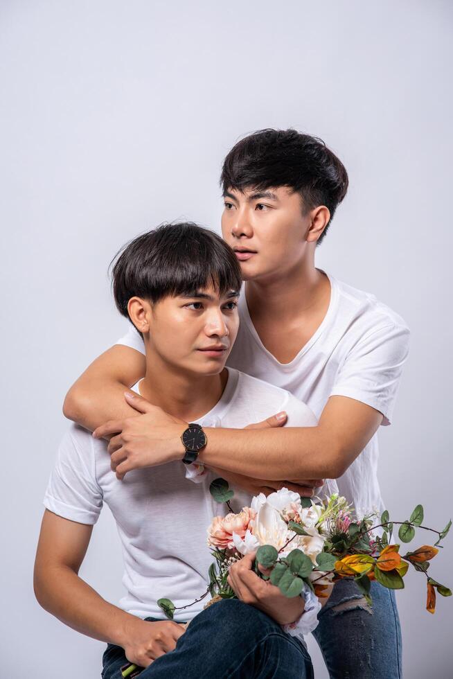 Two men who love each other hug from behind another. photo