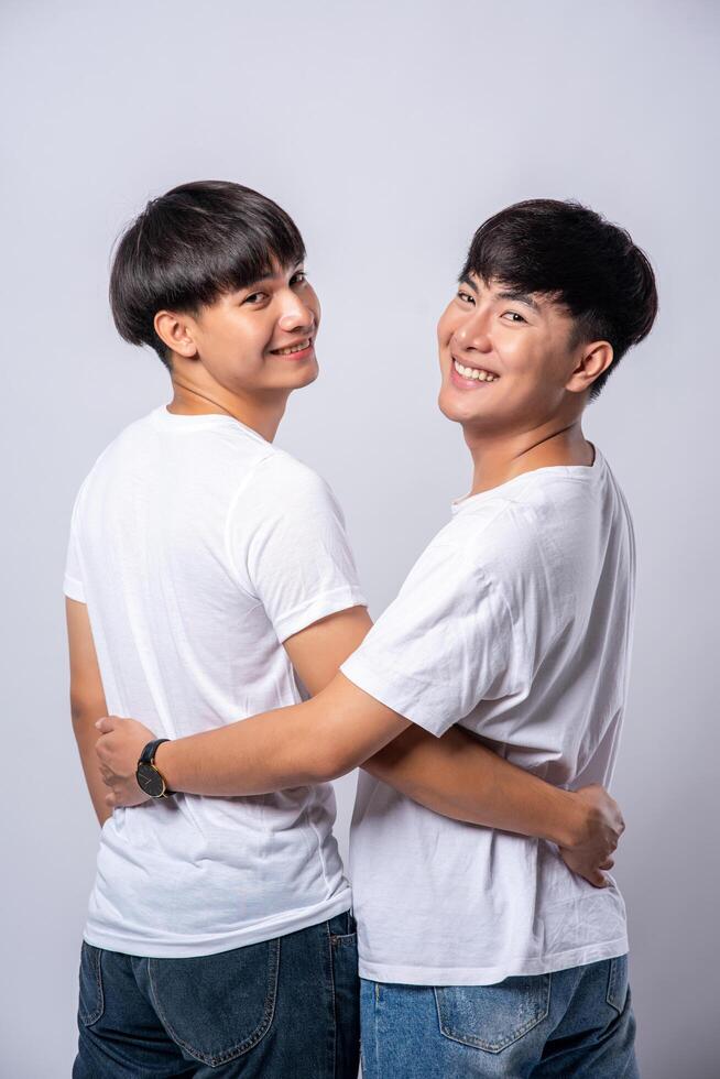 Two men who love each other hug from behind another. photo