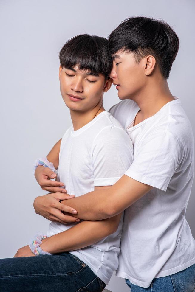 dos hombres que se aman se abrazan por detrás del otro. foto