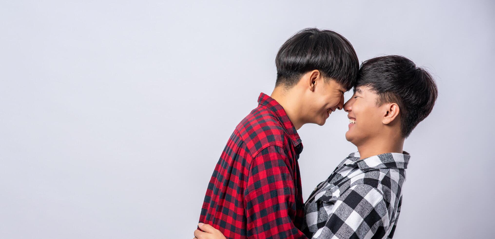 Two men who love each other happily hug each other. photo