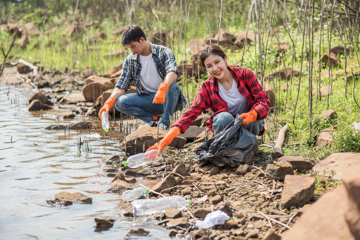 Men and women help each other to collect garbage. photo