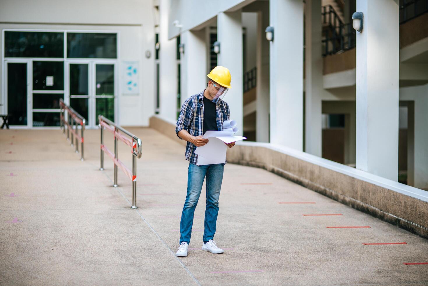 los arquitectos sostienen el plano del edificio y controlan el trabajo. foto