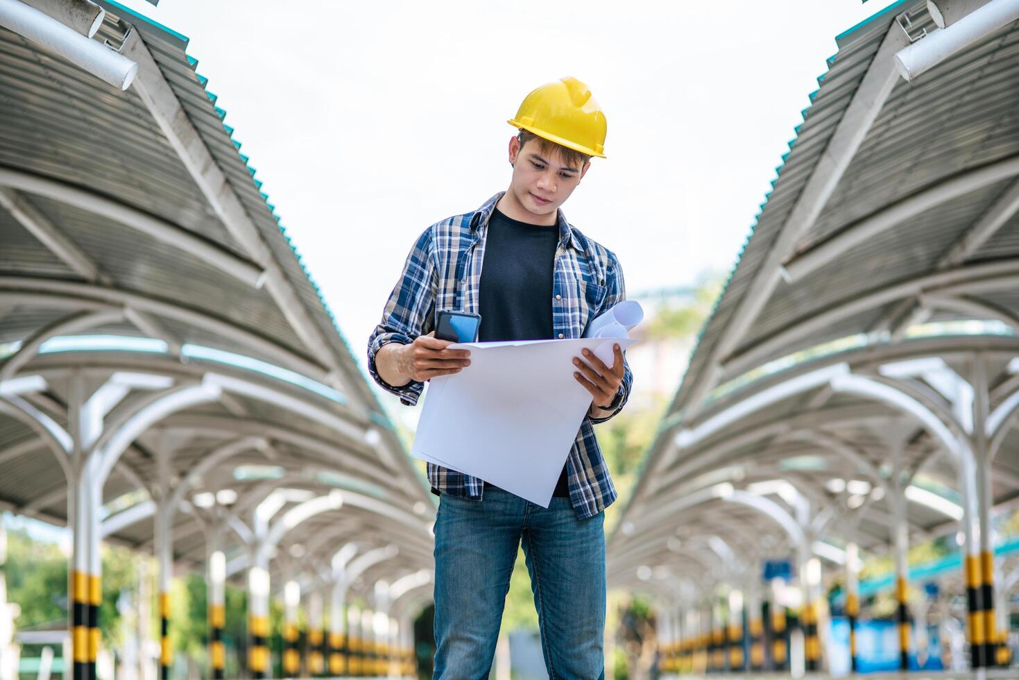 Architects hold the building plan and check the work. photo