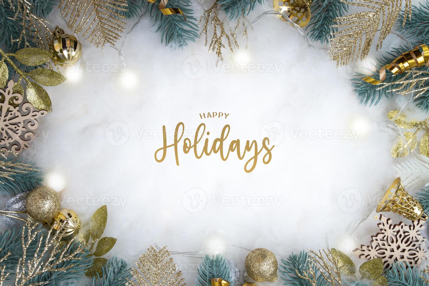 Happy Holidays text with frame made of Christmas decorations flat lay on snowy background photo