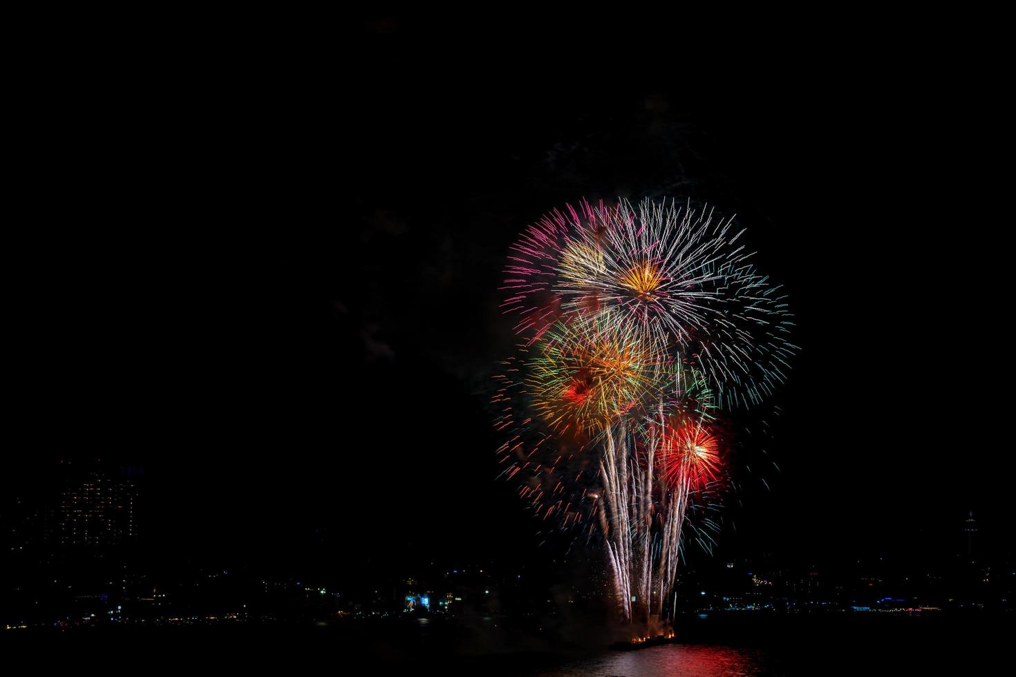 coloridos fuegos artificiales de varios colores en la noche con concepto de celebración y aniversario foto