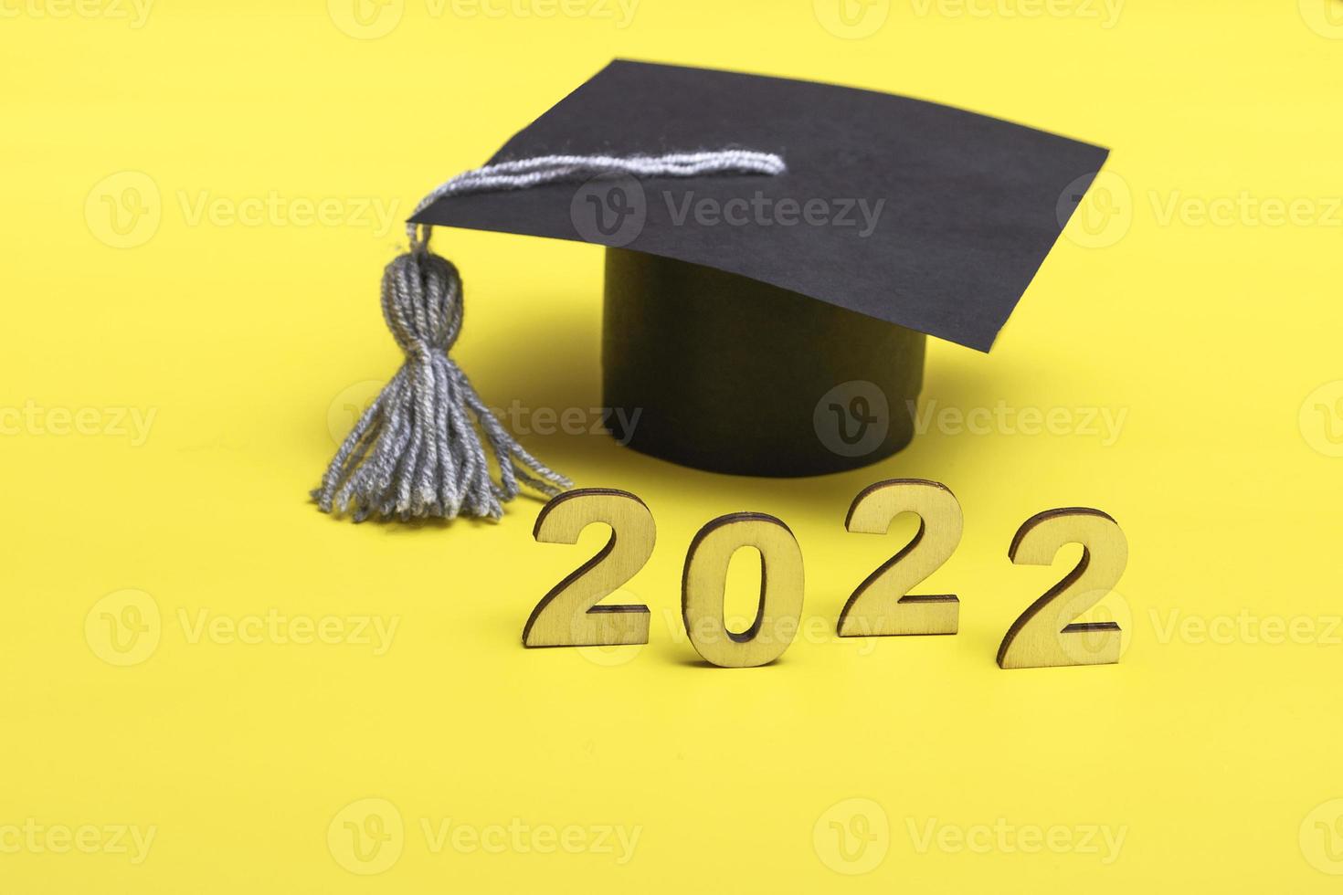 Gift box in the form of a graduation cap. 2022 release concept on yellow background copy space photo