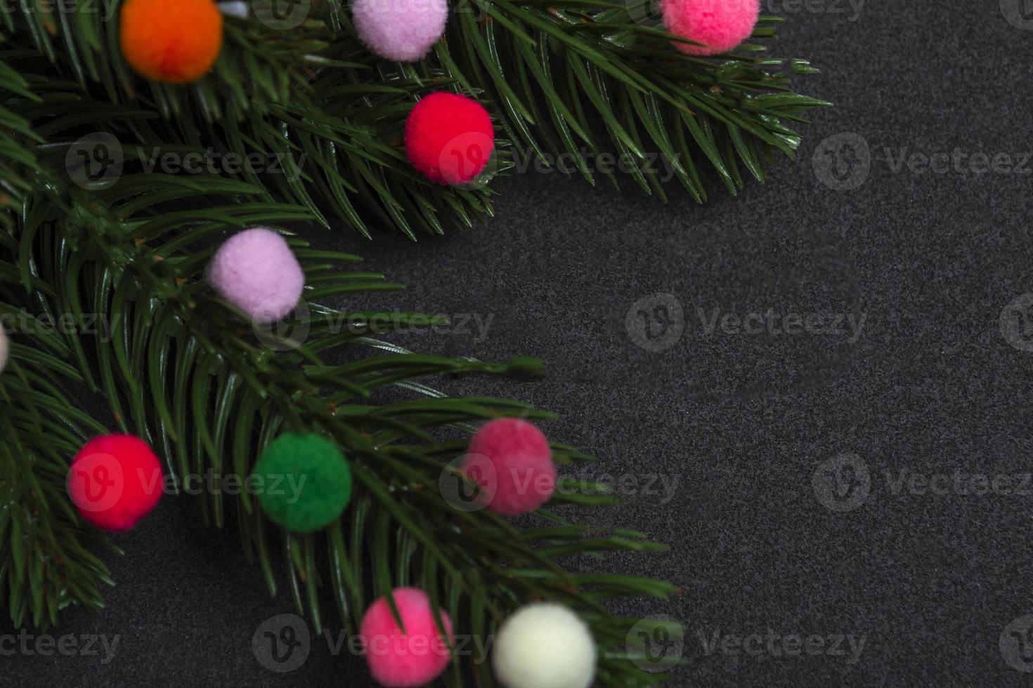 Christmas card. Flatley branches of a Christmas tree colorful fur toys on a black background. photo