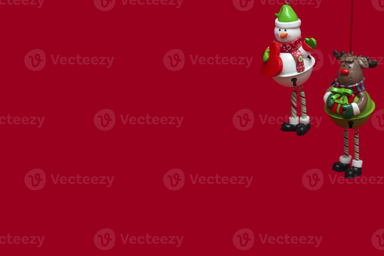 Isolated hanging Christmas toys on a red background snowman and snow deer. concept for New Year greeting card, invitation and packaging photo