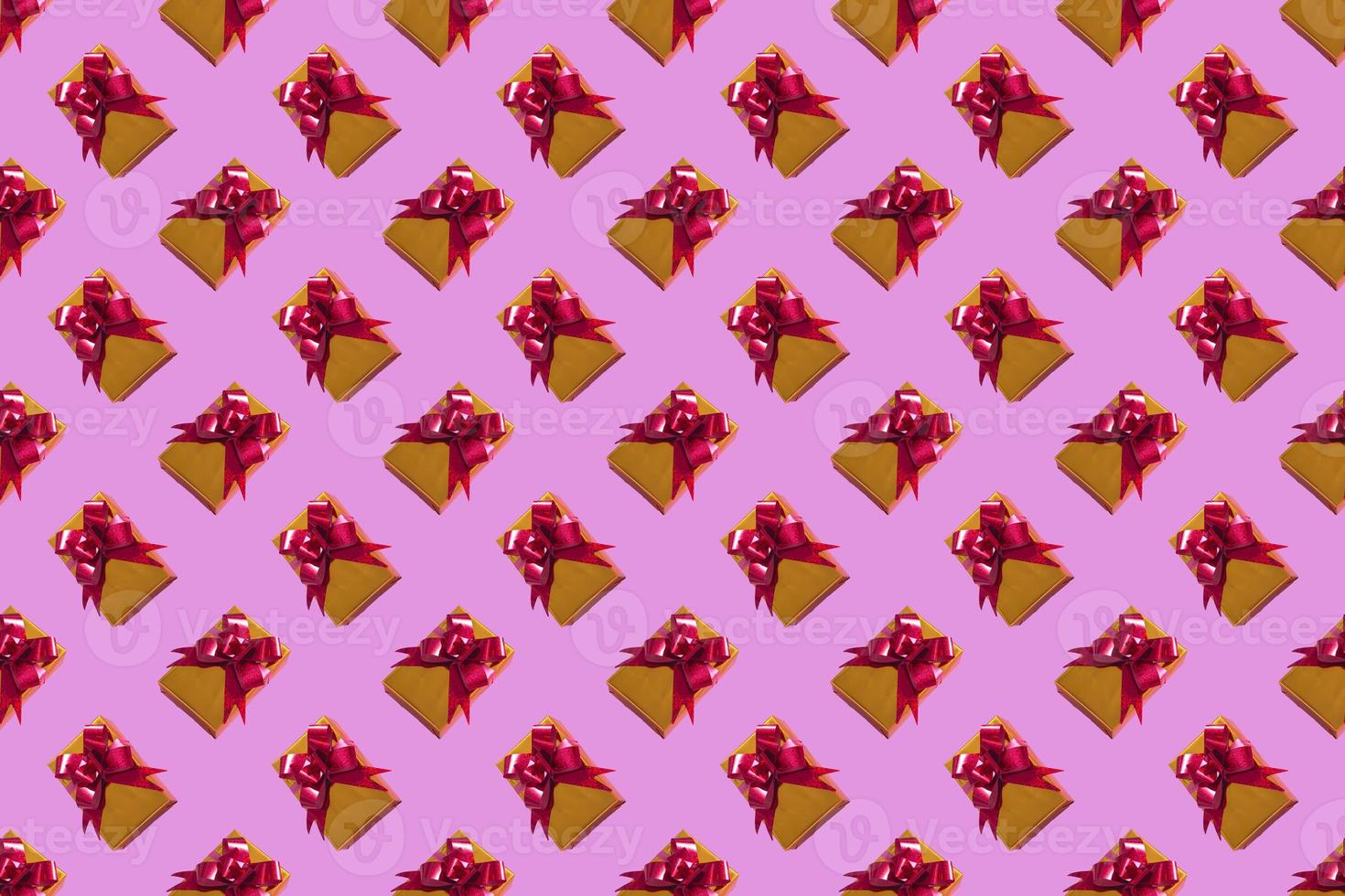 New Year Christmas composition. Gold gift with a red bow on a pink background. Top View Copy Space New Year 2022 Christmas photo