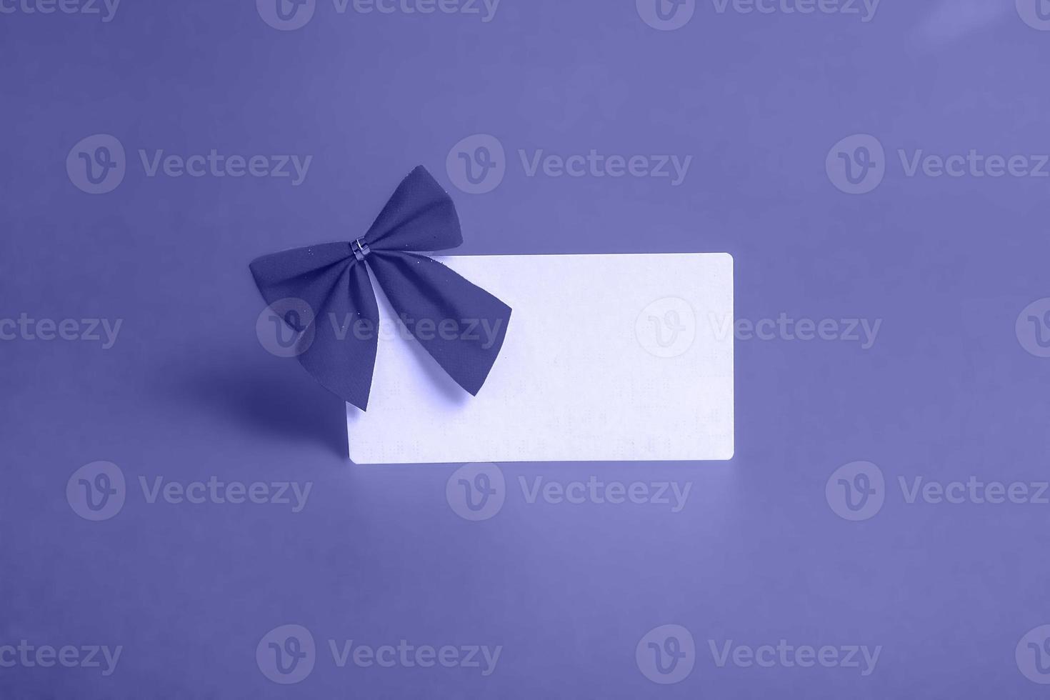 Blank card with a red bow on a very peri background. The concept of postcards, business cards. With copy space photo