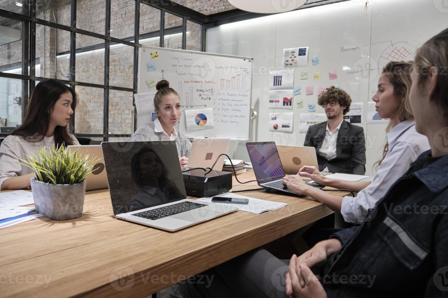 Meeting of a professional team, multiracial colleagues and coworkers brainstormed and presentation in conference room of business office with Caucasian male manager, discussing finance and marketing. photo