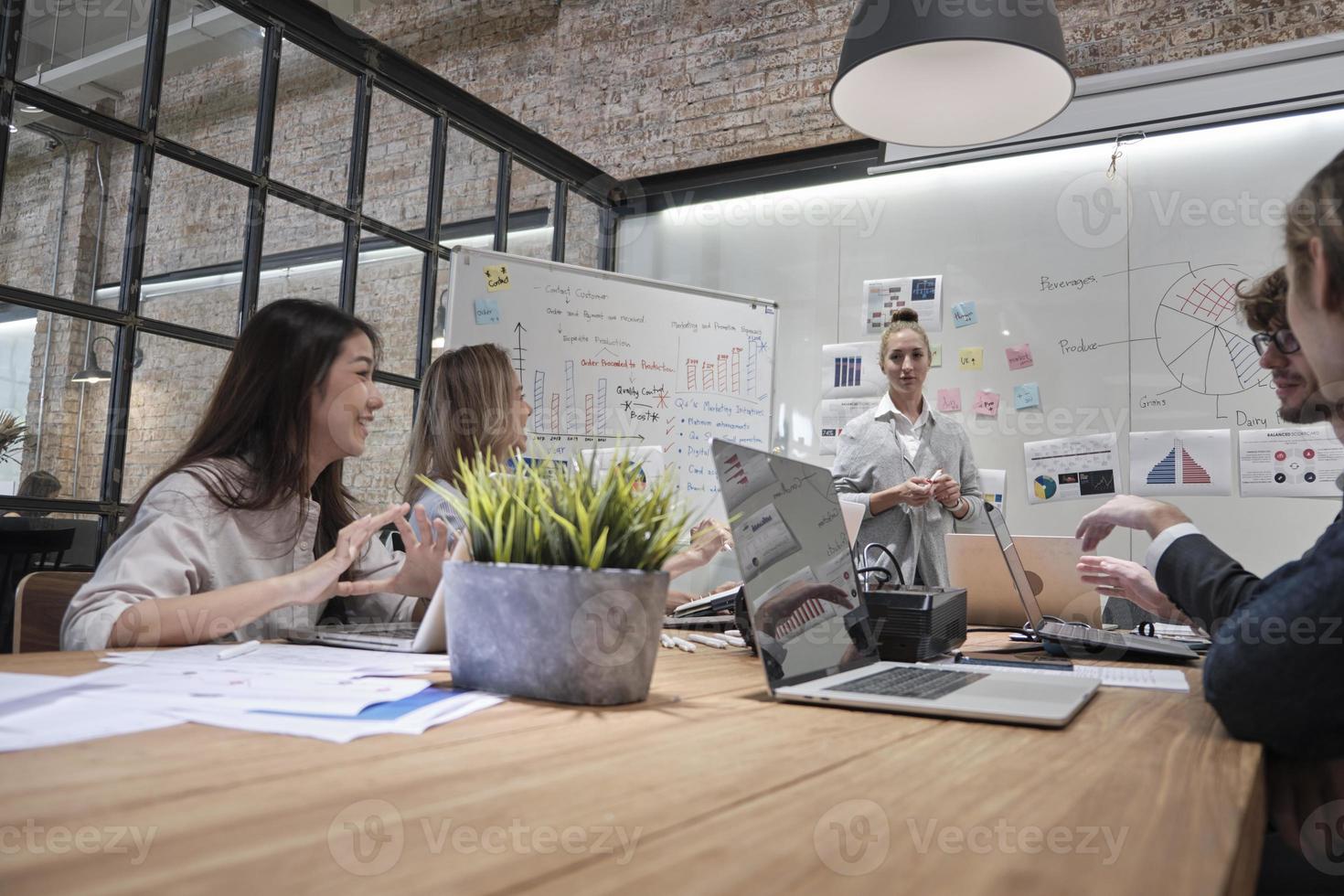 Meeting of a professional team, multiracial colleagues and coworkers brainstormed and presentation in conference room of business office with Cuacasian female boss, discussing finance and marketing. photo