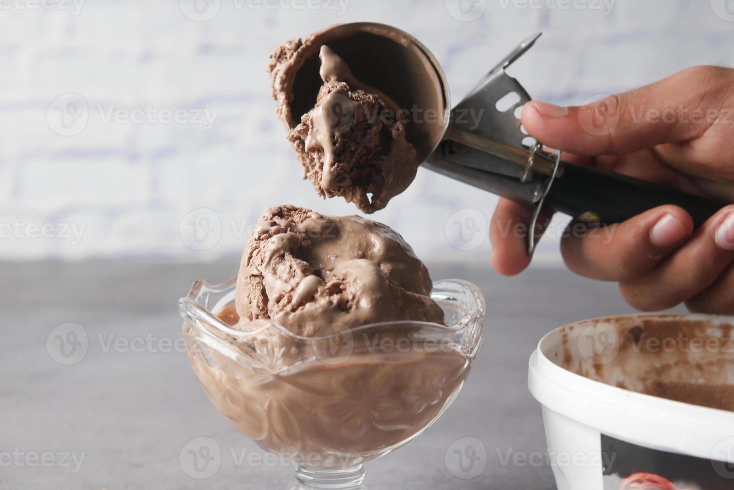 hand picking ice cream with a spoon from a bowl photo