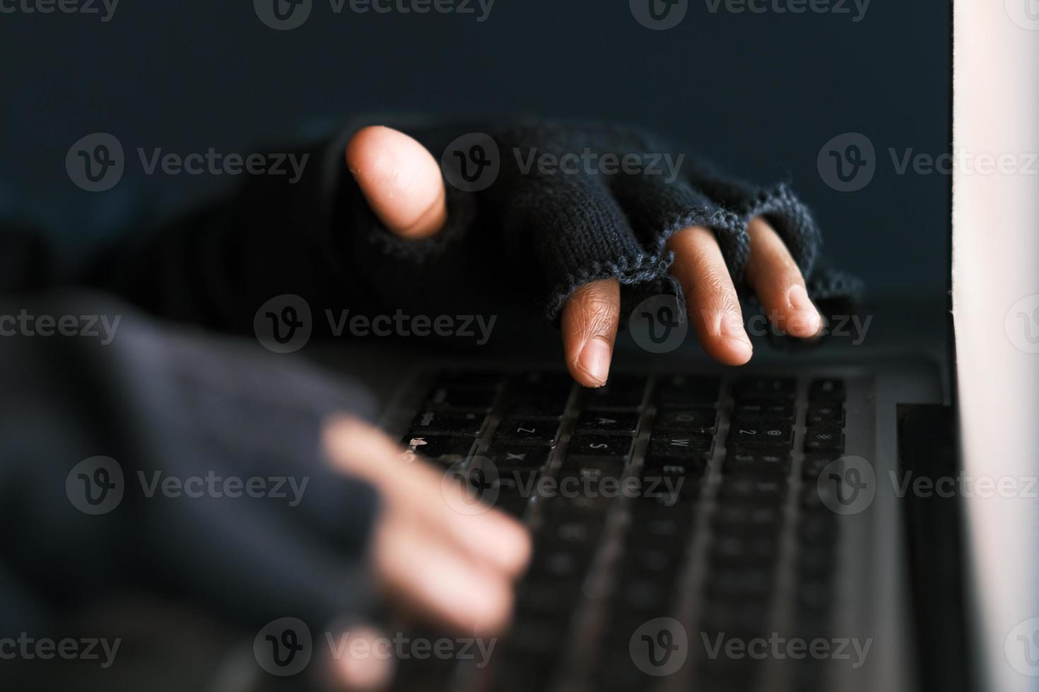 Mano de hacker robando datos de la computadora portátil de arriba hacia abajo foto