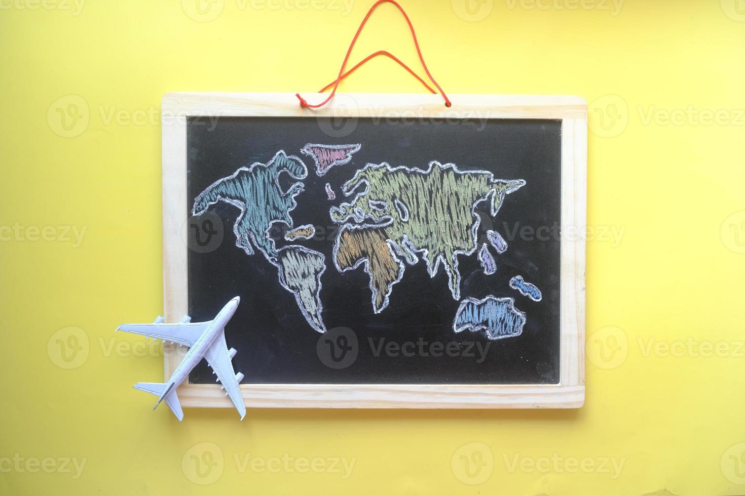 travel concept with a airplane on world map drown on chalk board photo