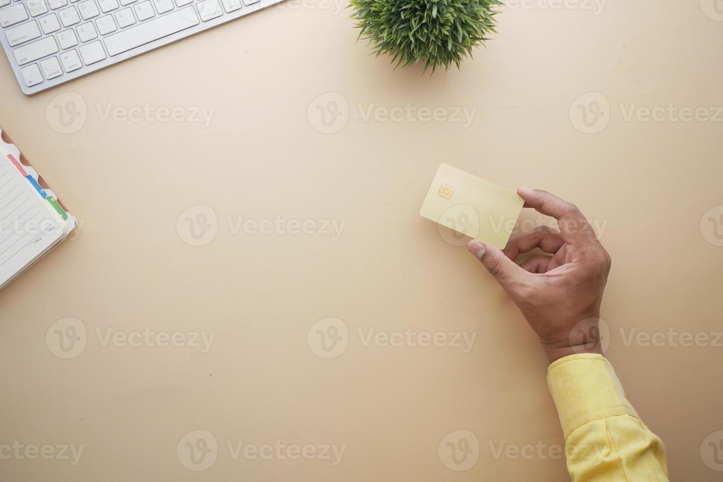 Cerca de la mano de la persona que sostiene la tarjeta de crédito foto