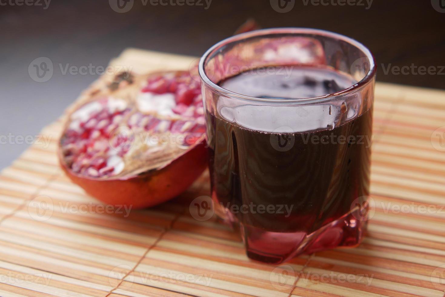 glass on pomegranate juice on red background . photo