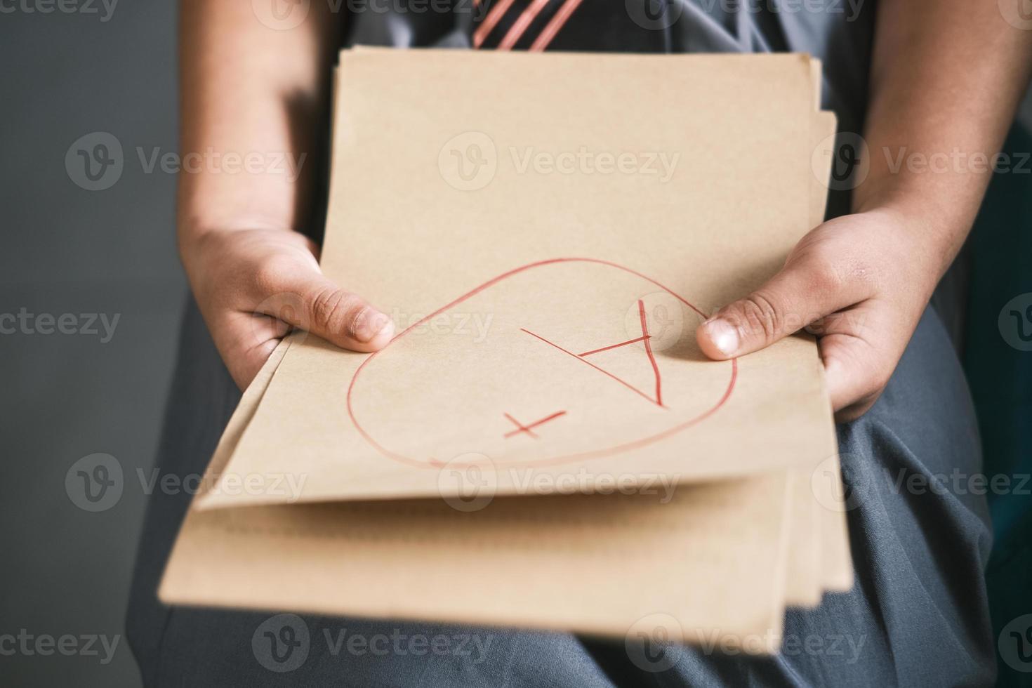 hand holding paper with Hand drawn grade with plus in circle photo
