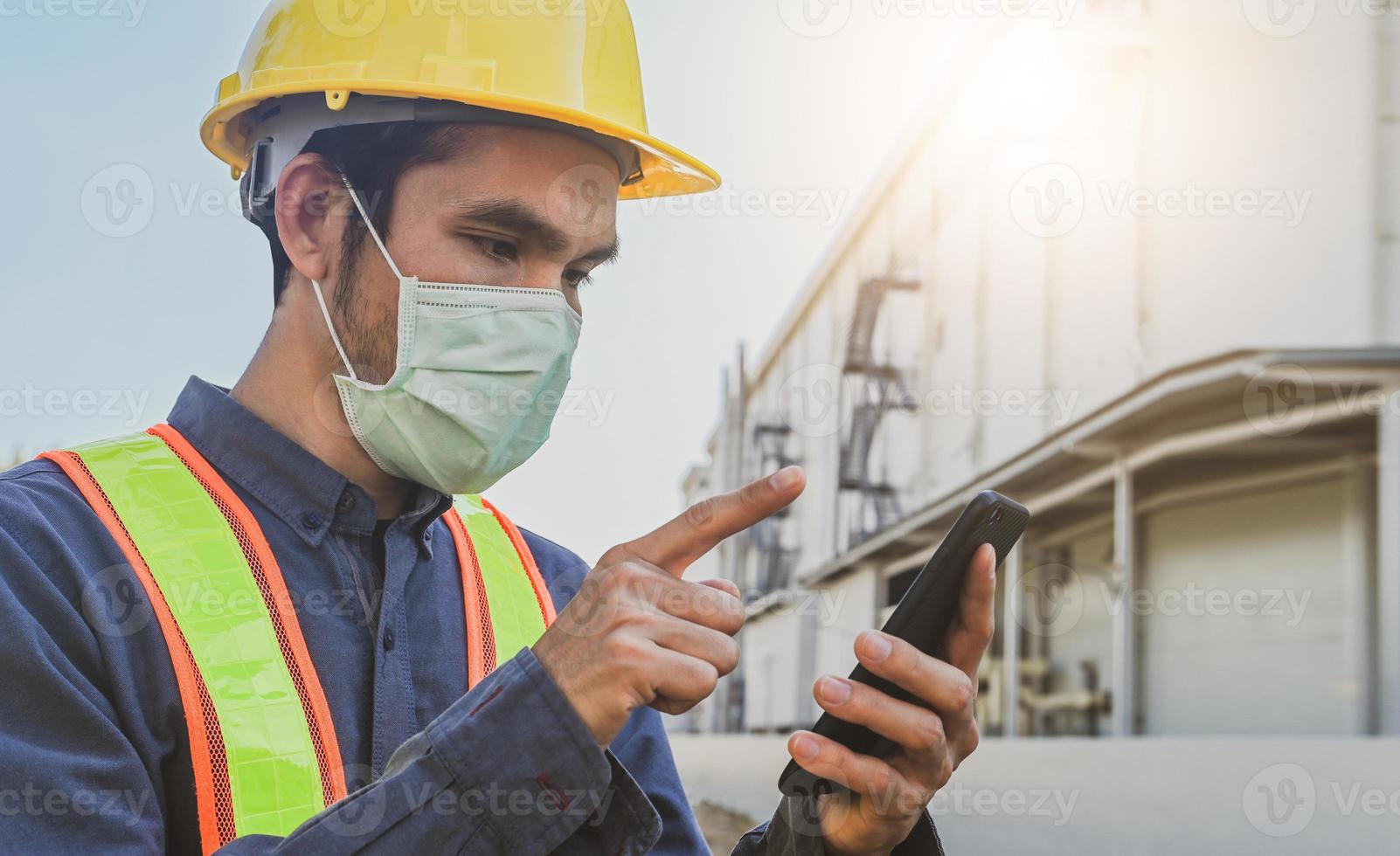 ingeniero sosteniendo teléfono inteligente enviar mensaje tecnología de internet, ingeniero construcción inspección proyecto de construcción foto